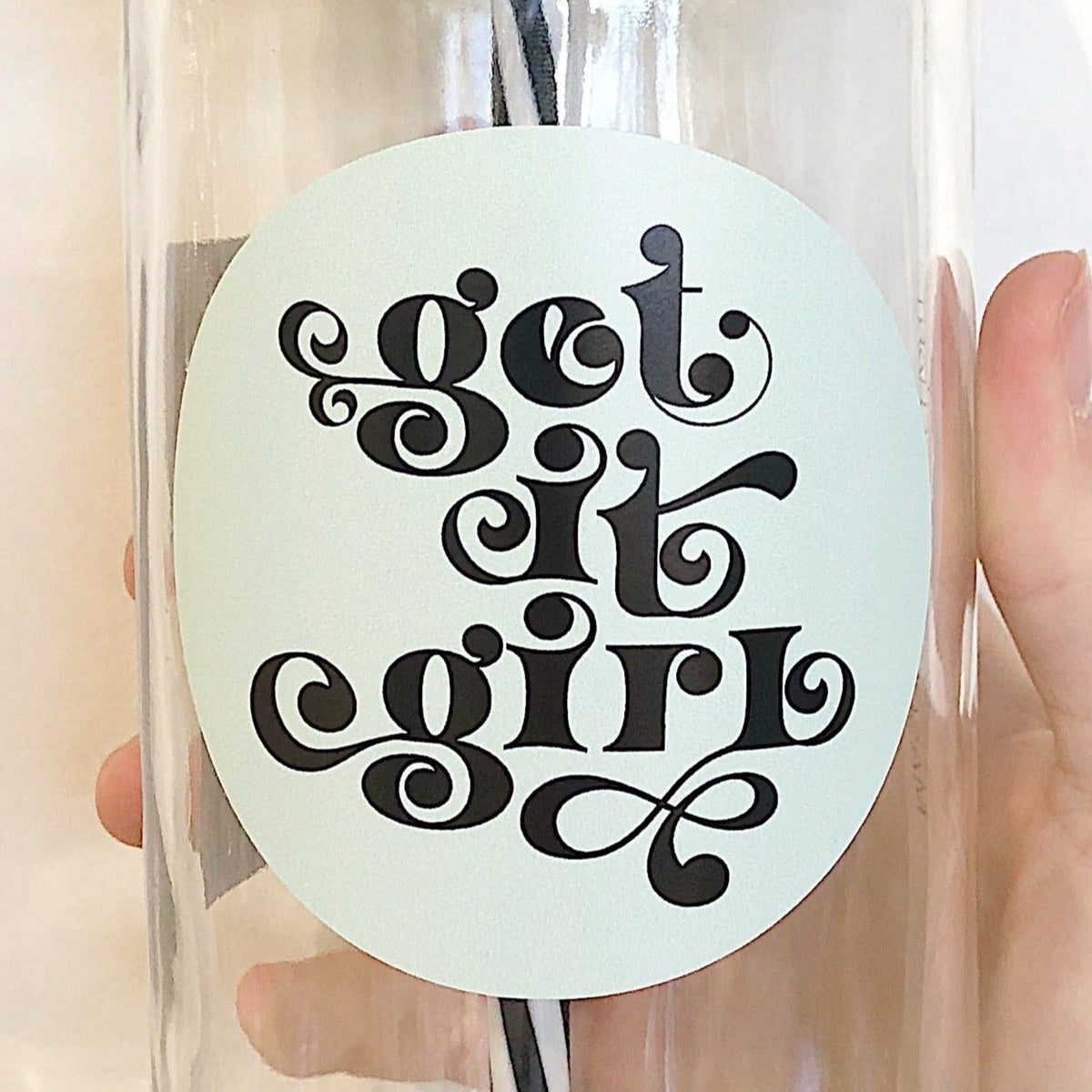 Close up of a hand holding a mason jar tumbler that says “get it girl”