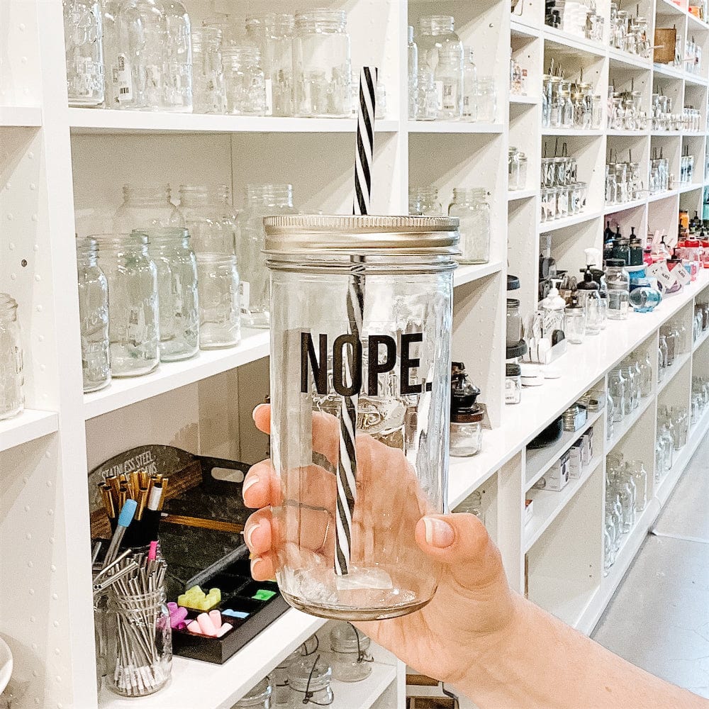 Hand holding a mason jar tumbler that says “NOPE.”