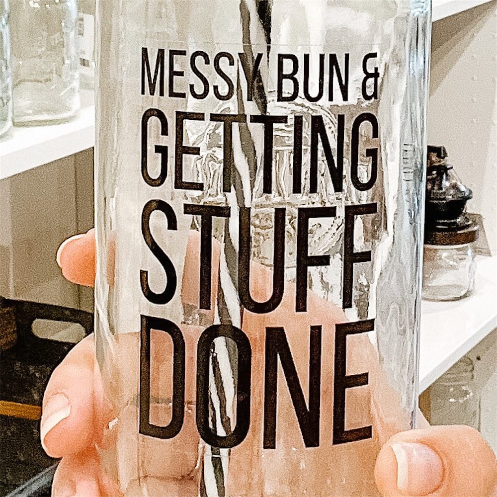 Close up of a hand holding a mason jar tumbler that says “messy bun & getting stuff done”