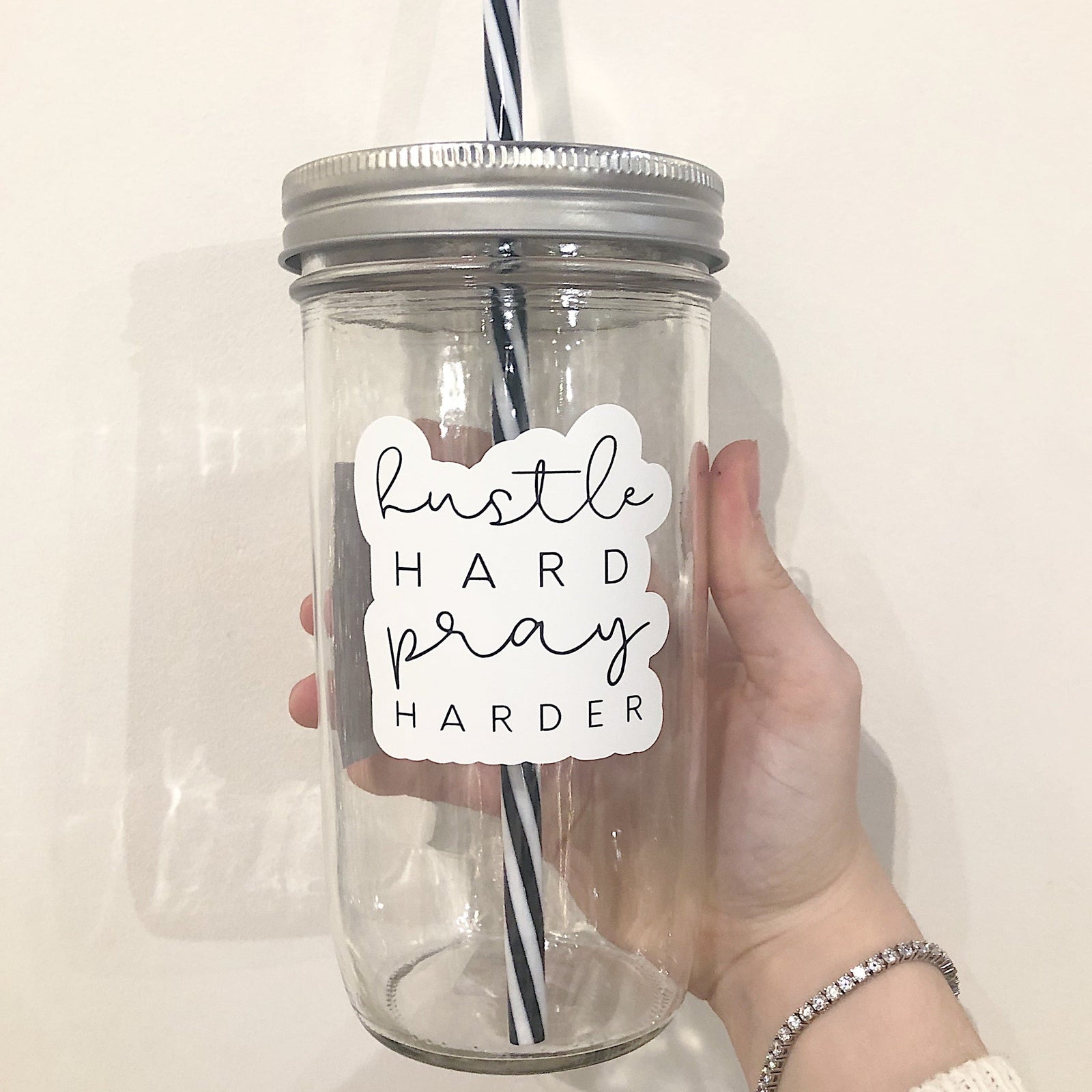 Mason jar tumbler that says “hustle hard, pray harder”