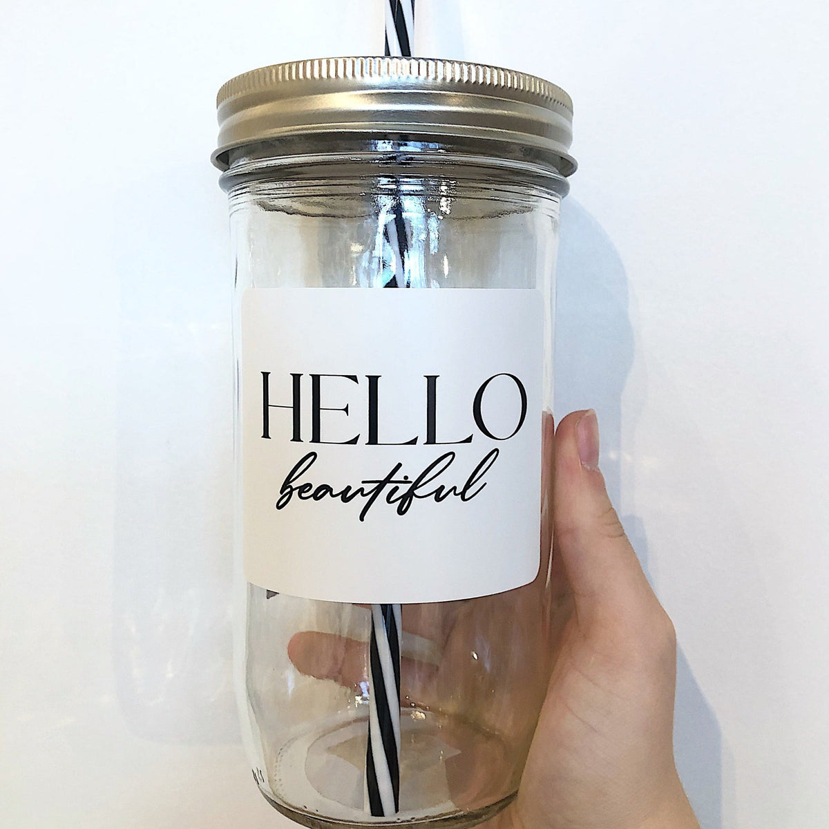 Mason jar tumbler that says “Hello beautiful” in black on a white background