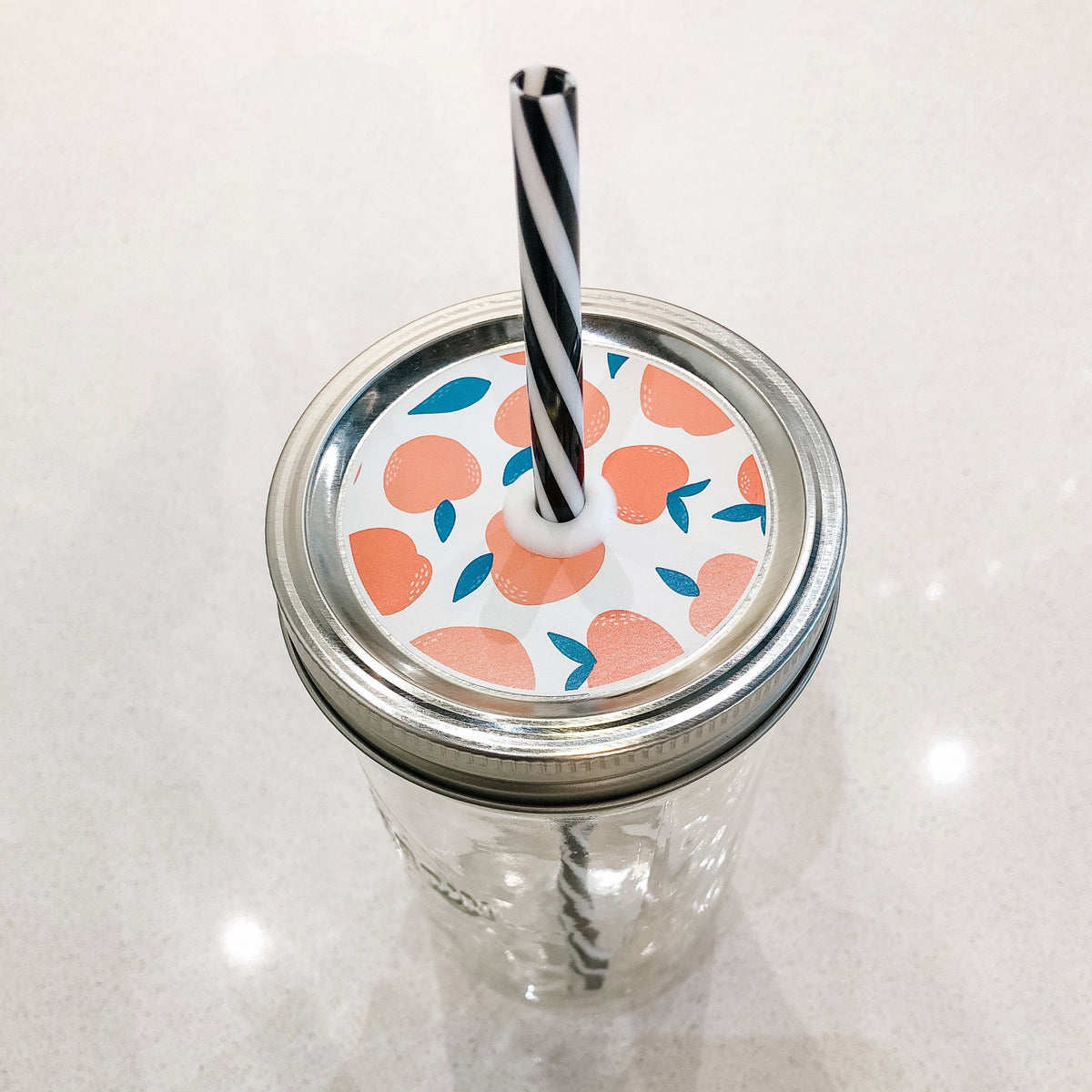 Photo of mason jar straw lid with peaches on print.