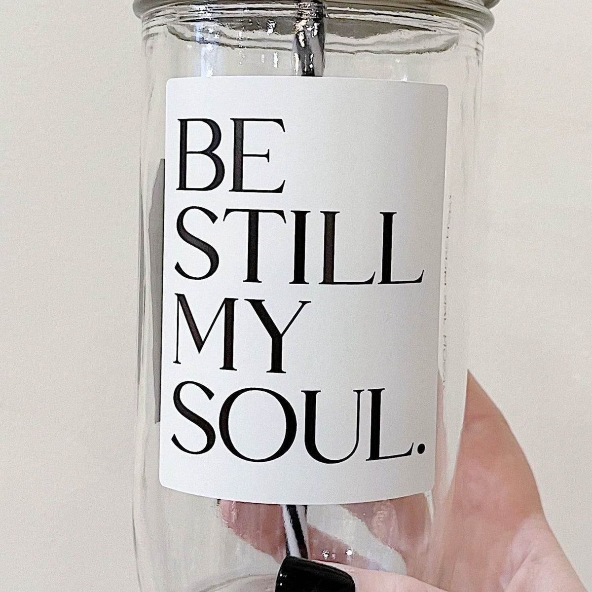 Close up of a mason jar tumbler that says “be still my soul”