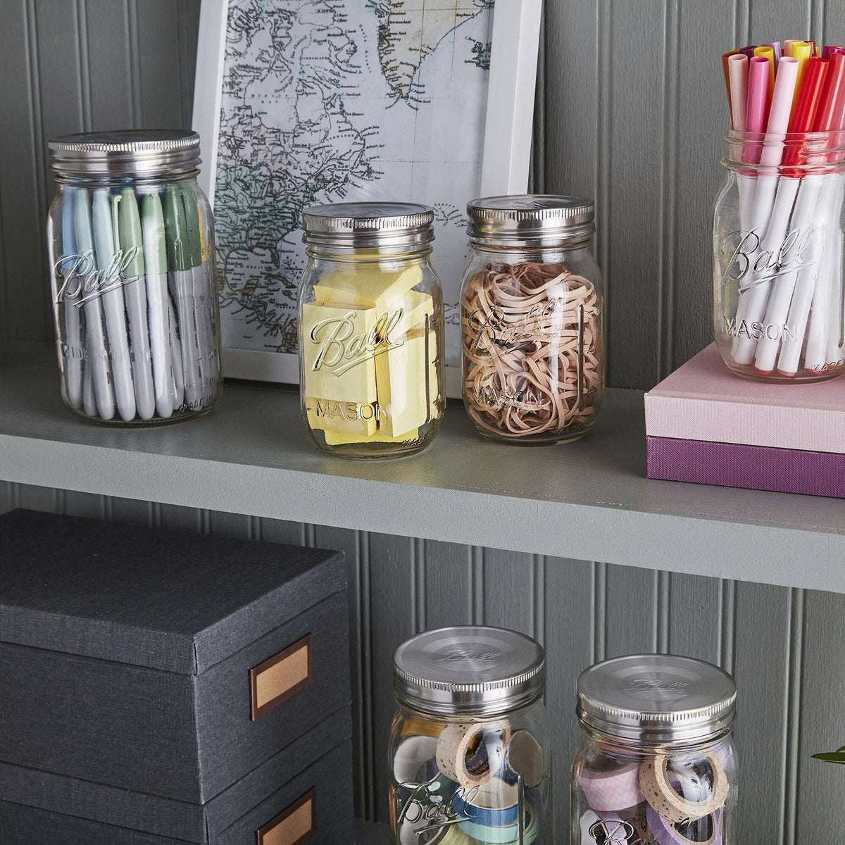 mason jars with stainless steel lids on top with various office supplies inside