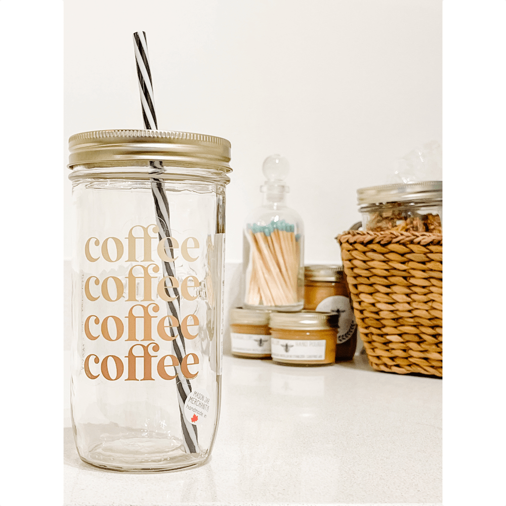 Photo of a mason jar with a gold lid and a black and white spiral straw. Small jars and a basket as a background. The mason jar tumbler reads coffee 4 times in different shades of brown.