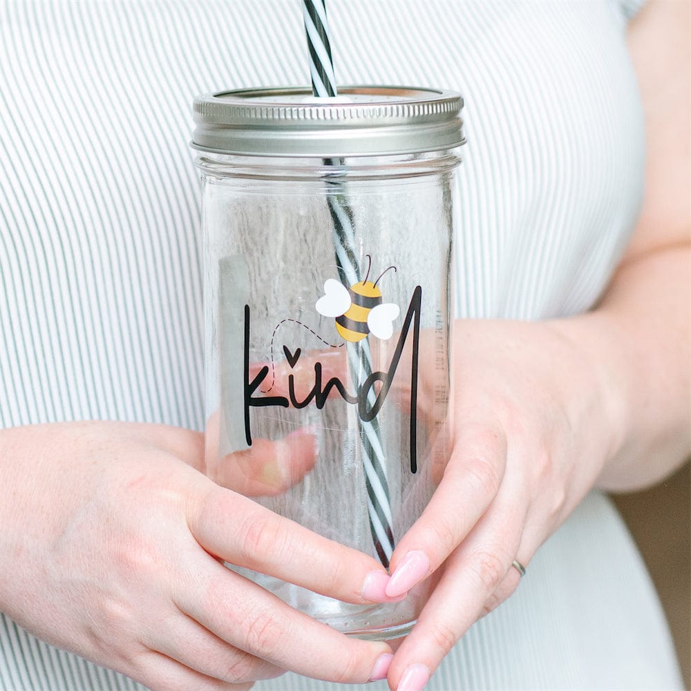 Photo of a mason jar tumbler with print of a bee and a word that says "kind".