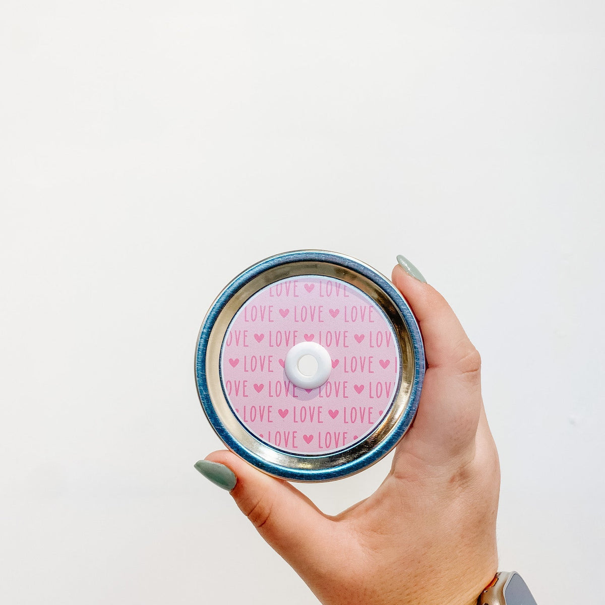 straw lid that has a light pink background with the word "LOVE" repeated in a darker pink