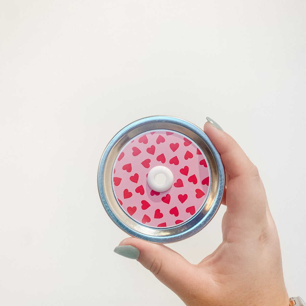 straw lid that has red hearts on a pink background