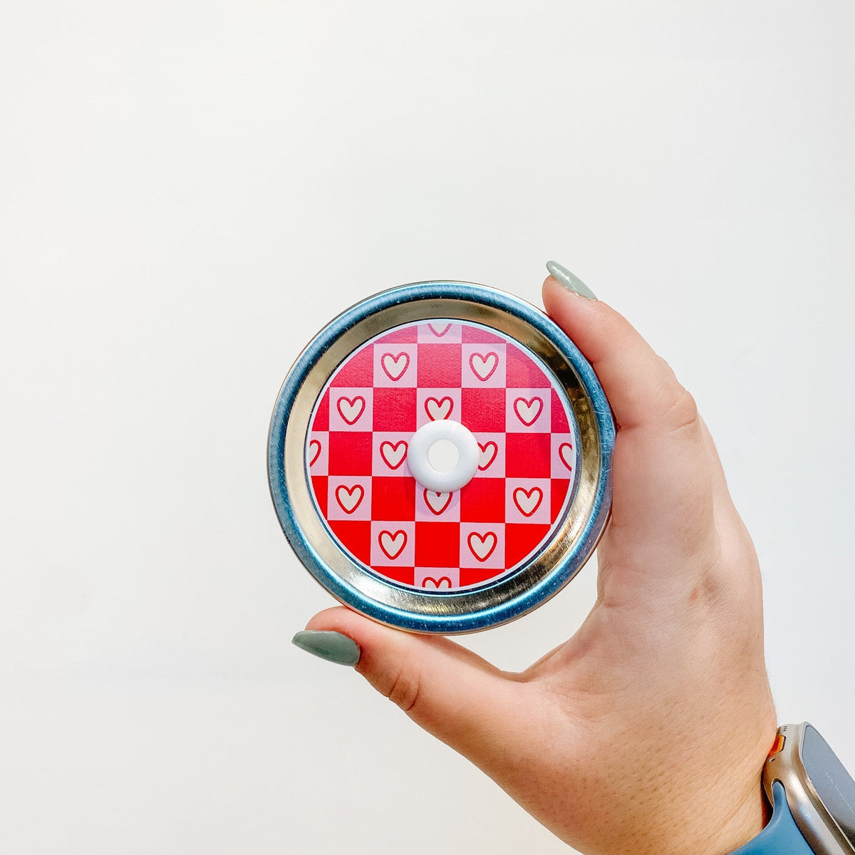 straw lid with a red and light pink checkerboard pattern, the light pink squares also have a cream coloured heart in each
