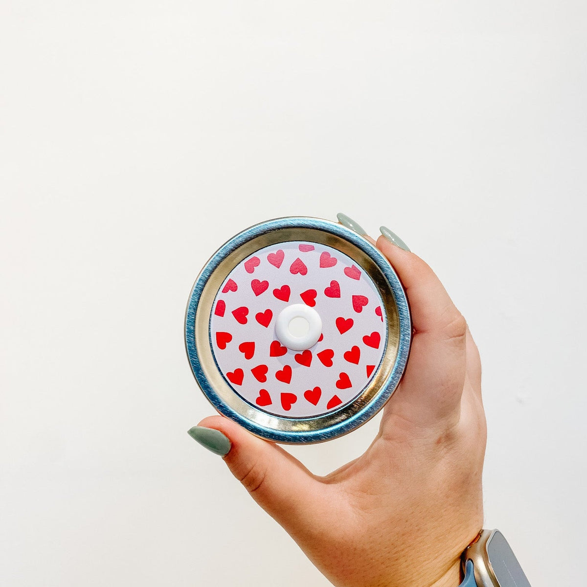 straw lid with red hearts on a light pink background