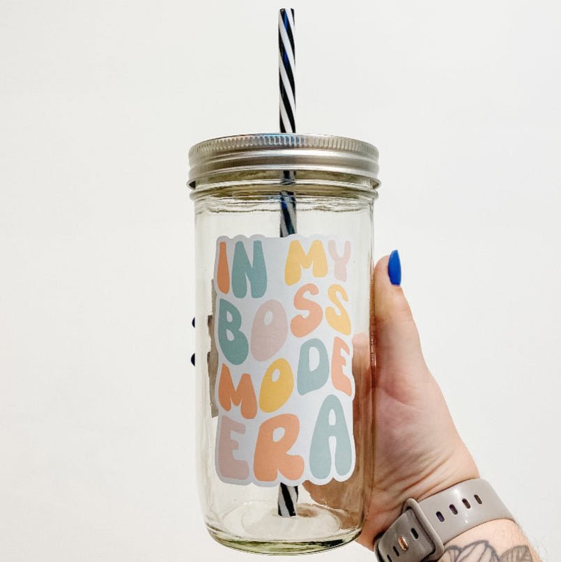 hand holding a mason jar tumbler that reads "in my boss mode era" the lettering is bubbly and in different shades of orange, yellow, pink, and blue