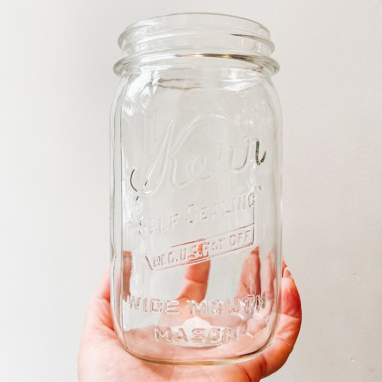 mason jar - says "Kerr" on a upwards slant, "self sealing" beneath, "reg. u.s. pat off" below in a rectangle, "WIDE MOUTH MASON" just above base