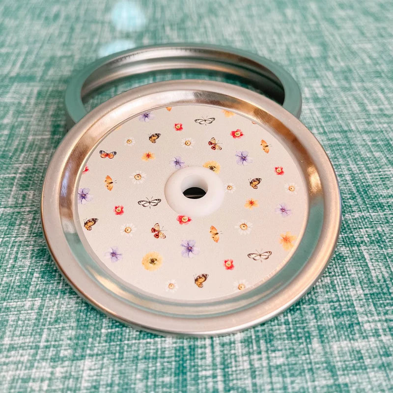 Mason jar patterned straw lid with mini assorted flowers and butterflies on white, almost light green background