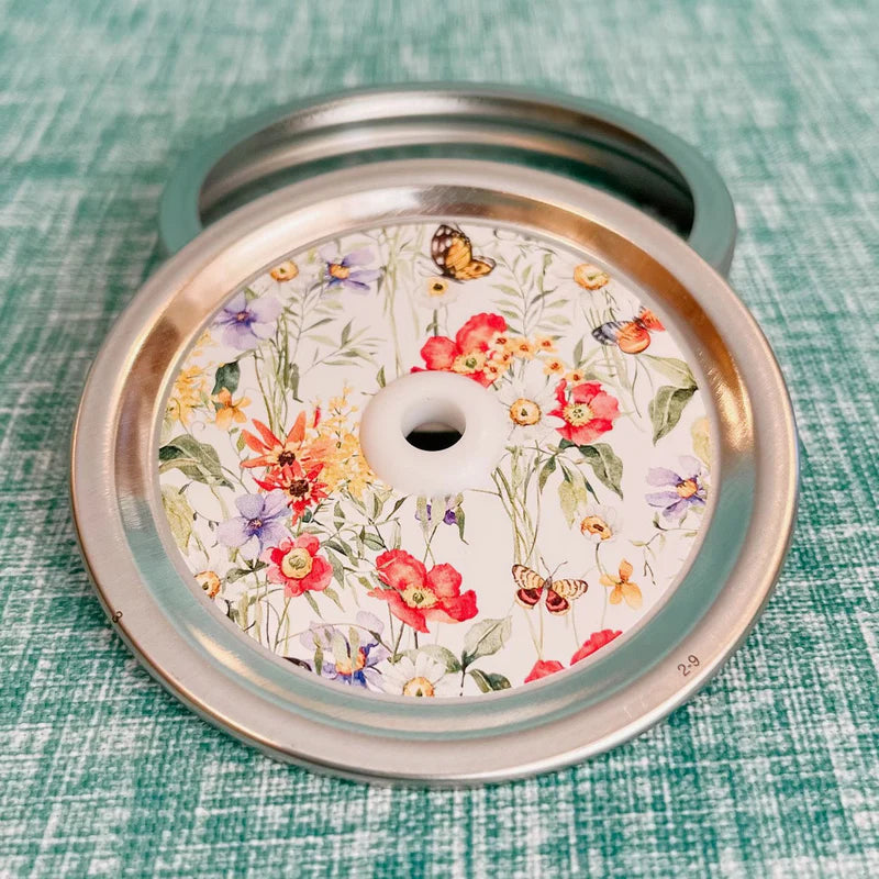 Mason jar patterned straw lid with multicolour and varieties of spring wildflowers and small butterflies on white background