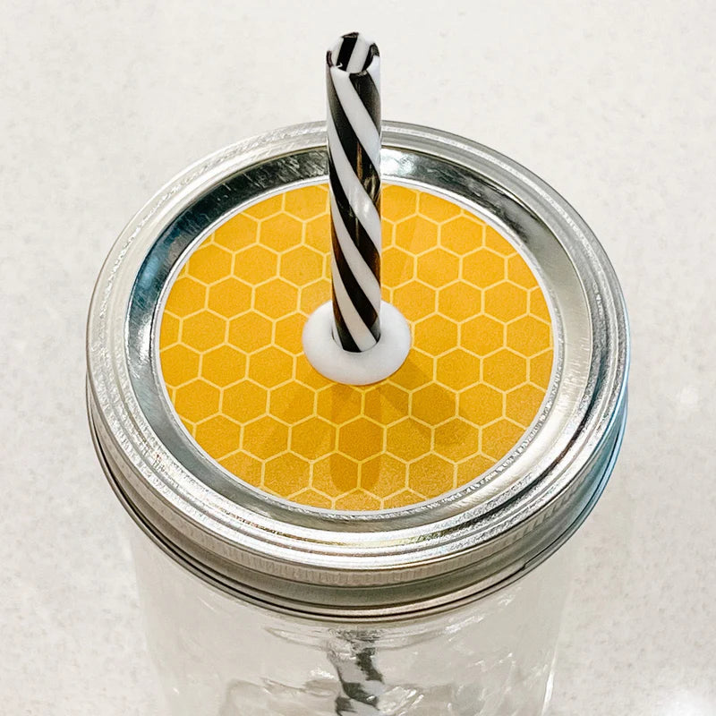 Picture shows mason jar patterned straw lid that is a bright yellow honey comb design
