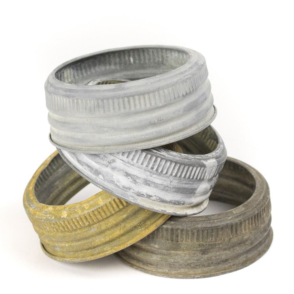 close up of four vintage zinc gem mouth rings, two grey, one yellow and one brown