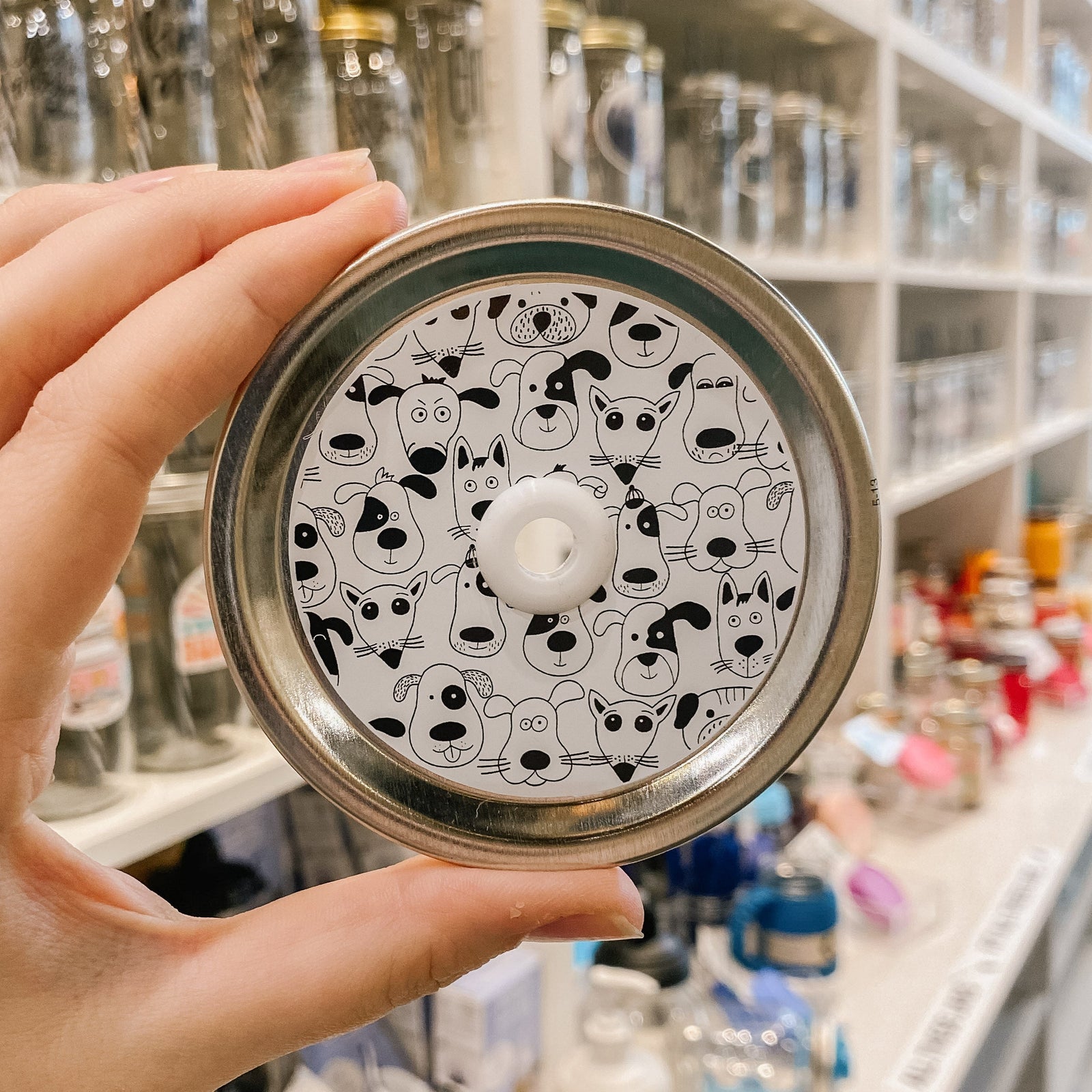 straw lid with white background and black line drawings of different dog faces