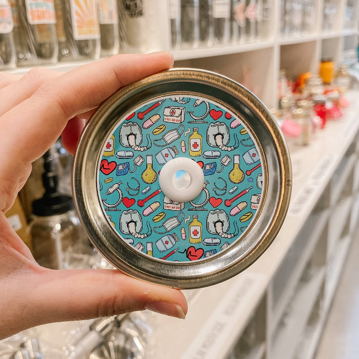 straw lid with a blue background with meds, masks, pills, blood pressure cuffs, hearts, and microscopes scattered across