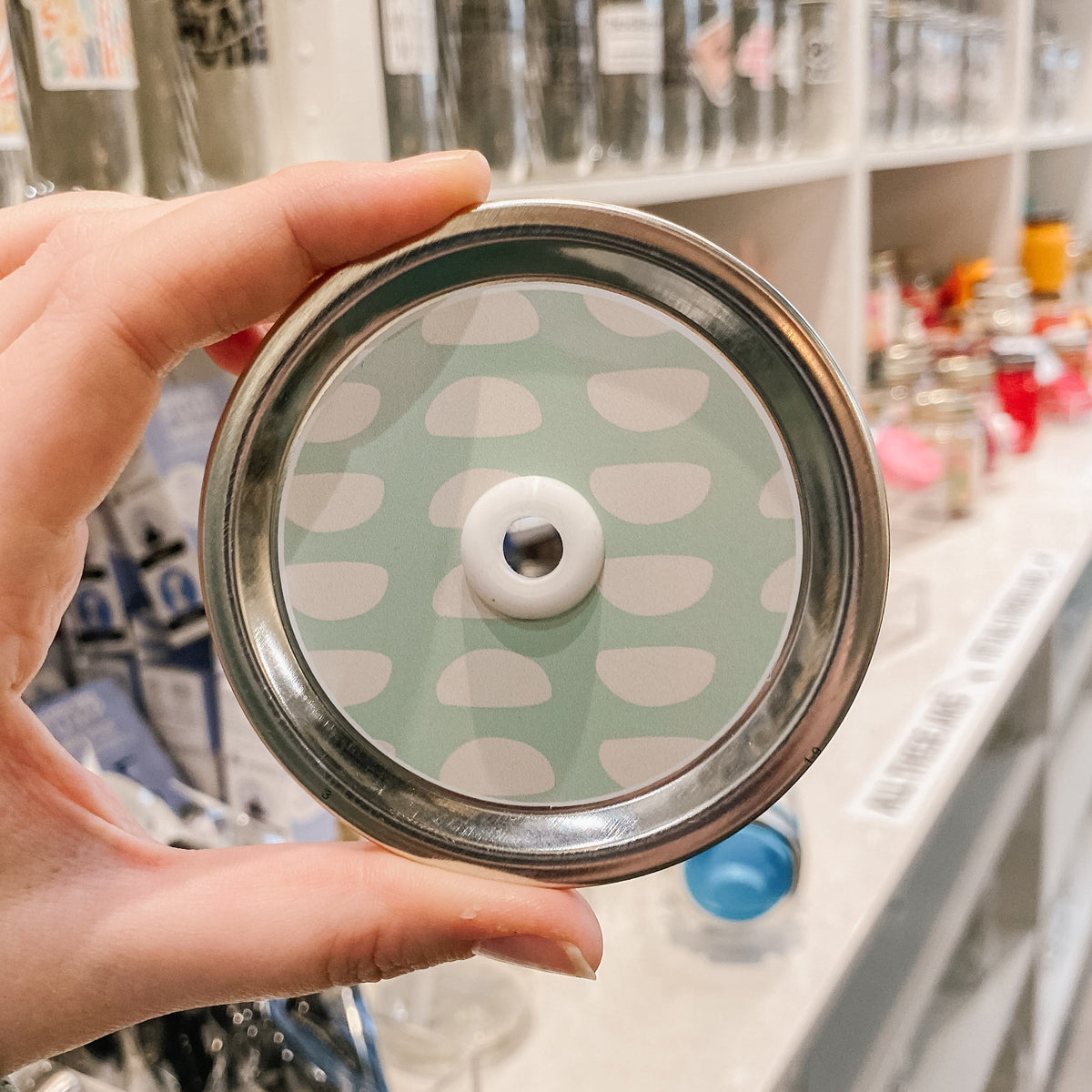 straw lid with a teal background and white semi circles patterned across