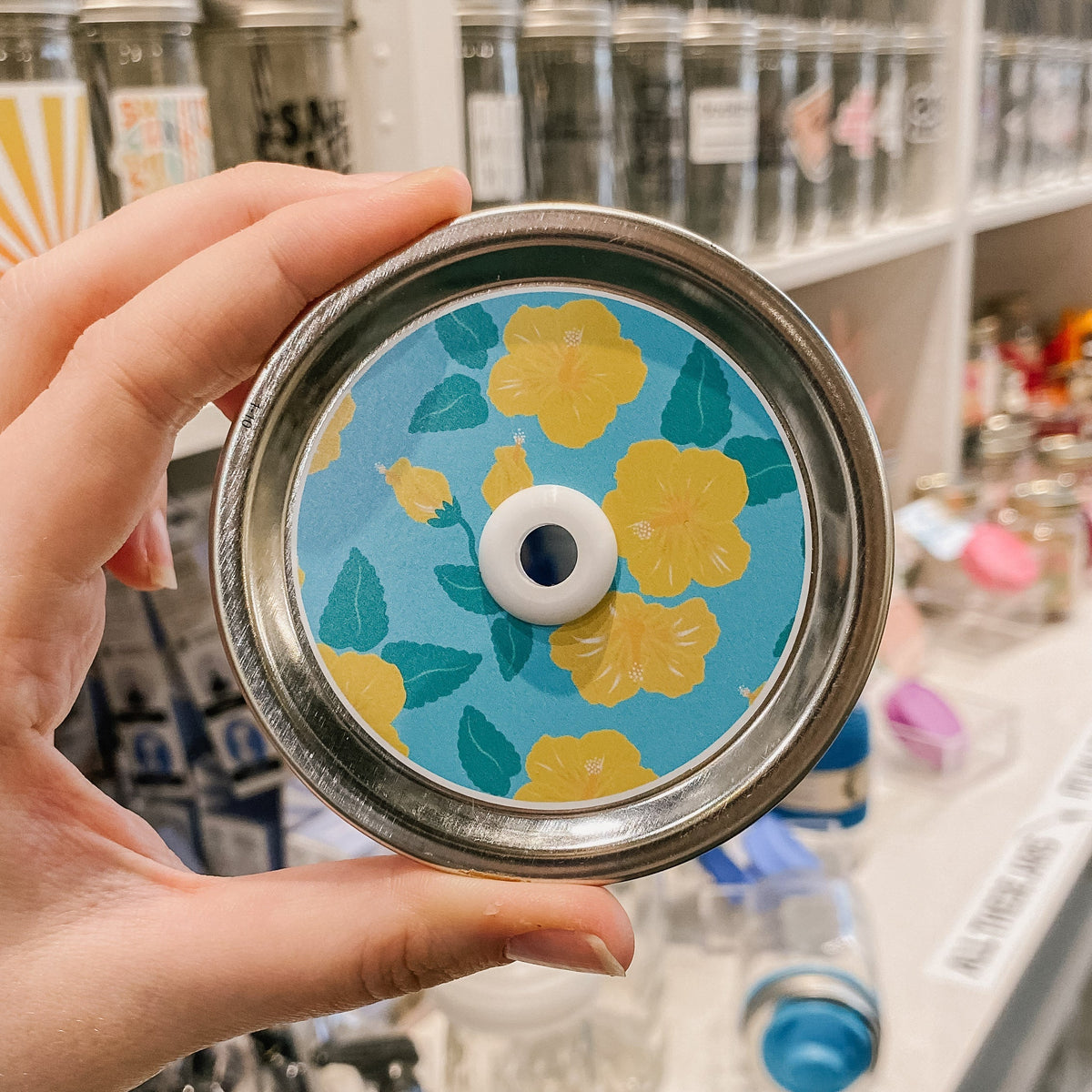 straw lid with a light blue background with yellow flowers and green leaves