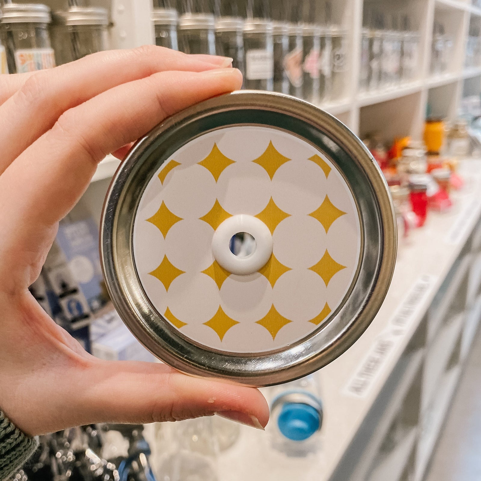 straw lid with a taupe background and yellow diamond/sparkles patterned across