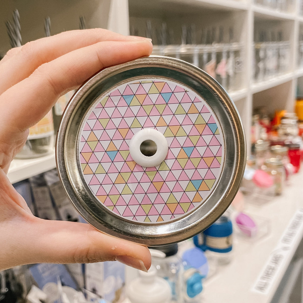 straw lid with a grid of triangles across the entire lid in blues, pinks, oranges, yellows, and white