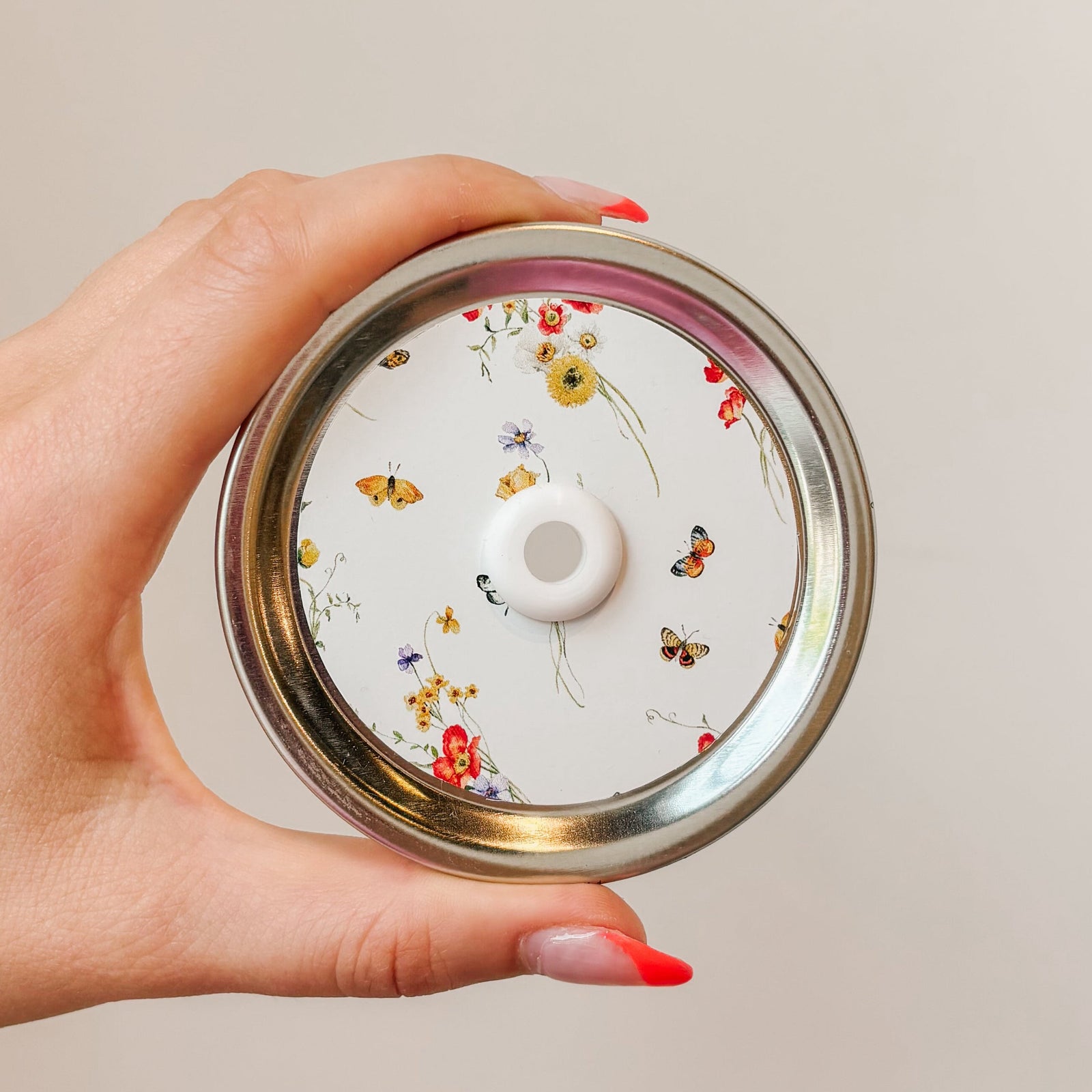 straw lid with a white background, bundles of flowers and butterflies scattered throughout