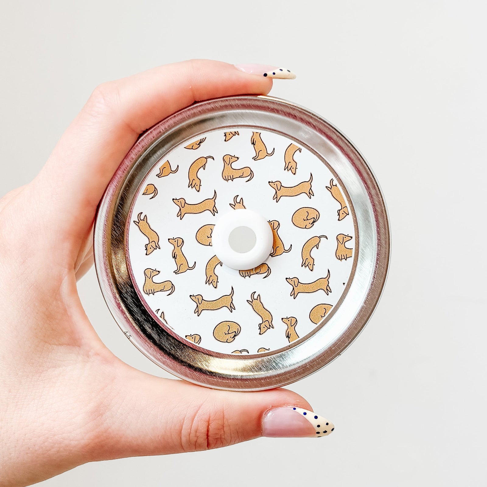 straw lid with white background and drawings of small weiner dogs