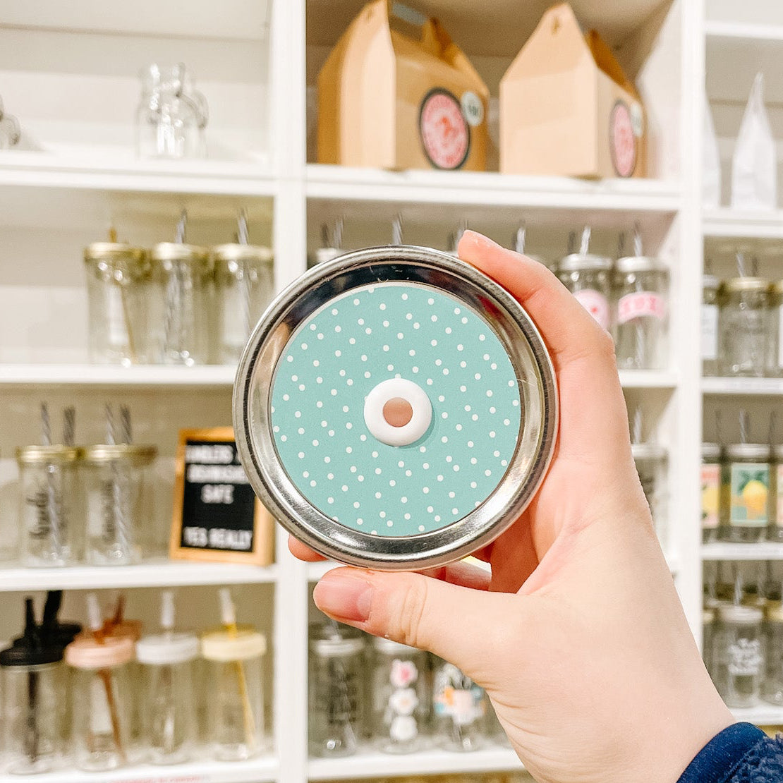 Hand holding a mason jar tumbler that says “fur mama” in teal with a small black paw print.