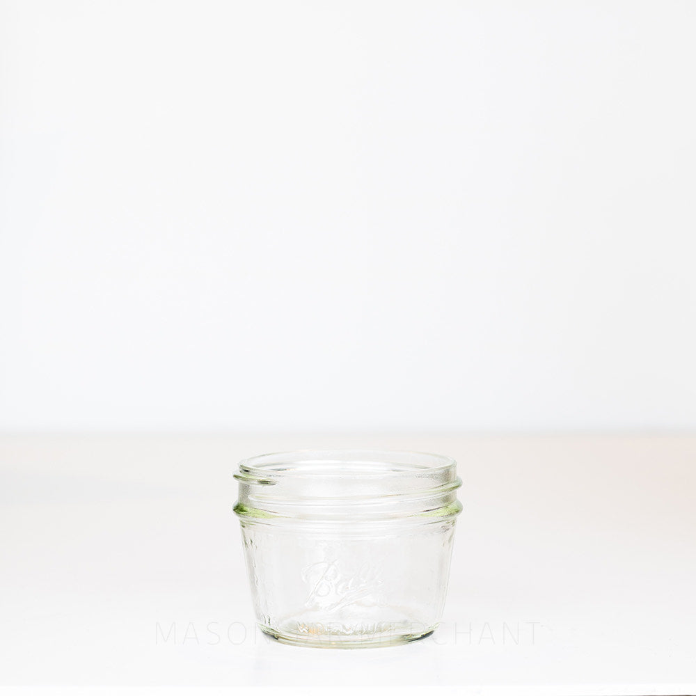 Wide mouth half pint mason jar with sloping sides and a Ball logo against a white background