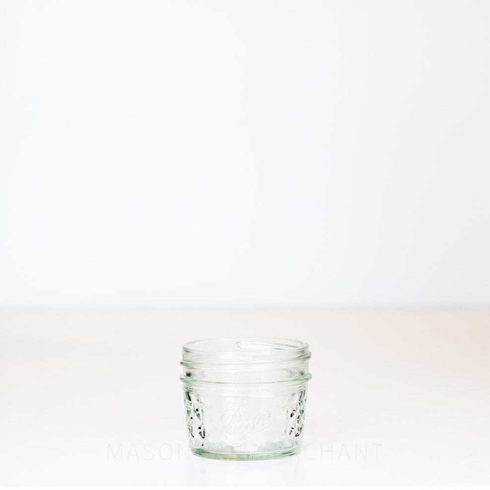 3 oz. regular mouth mason jar with quilted pattern on the sides and a Ball logo on the front, on a white background