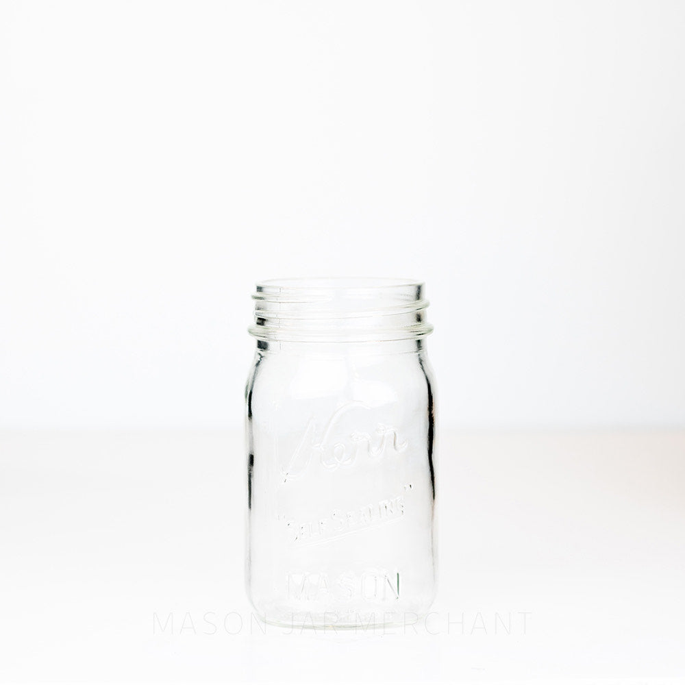 Kerr regular mouth pint mason jar with Self-sealing logo against a white background