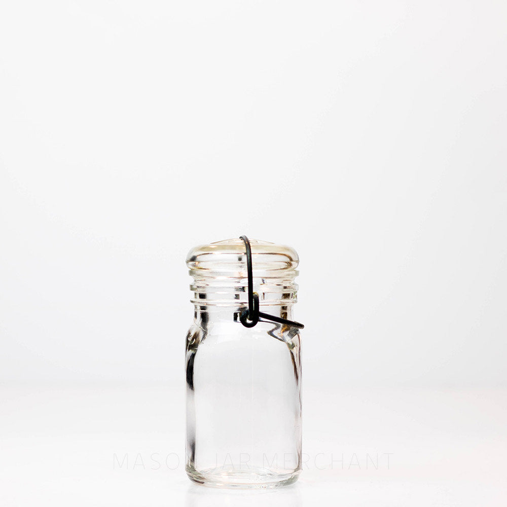 Vintage 1930s half pint wire bail mason jar against a white background