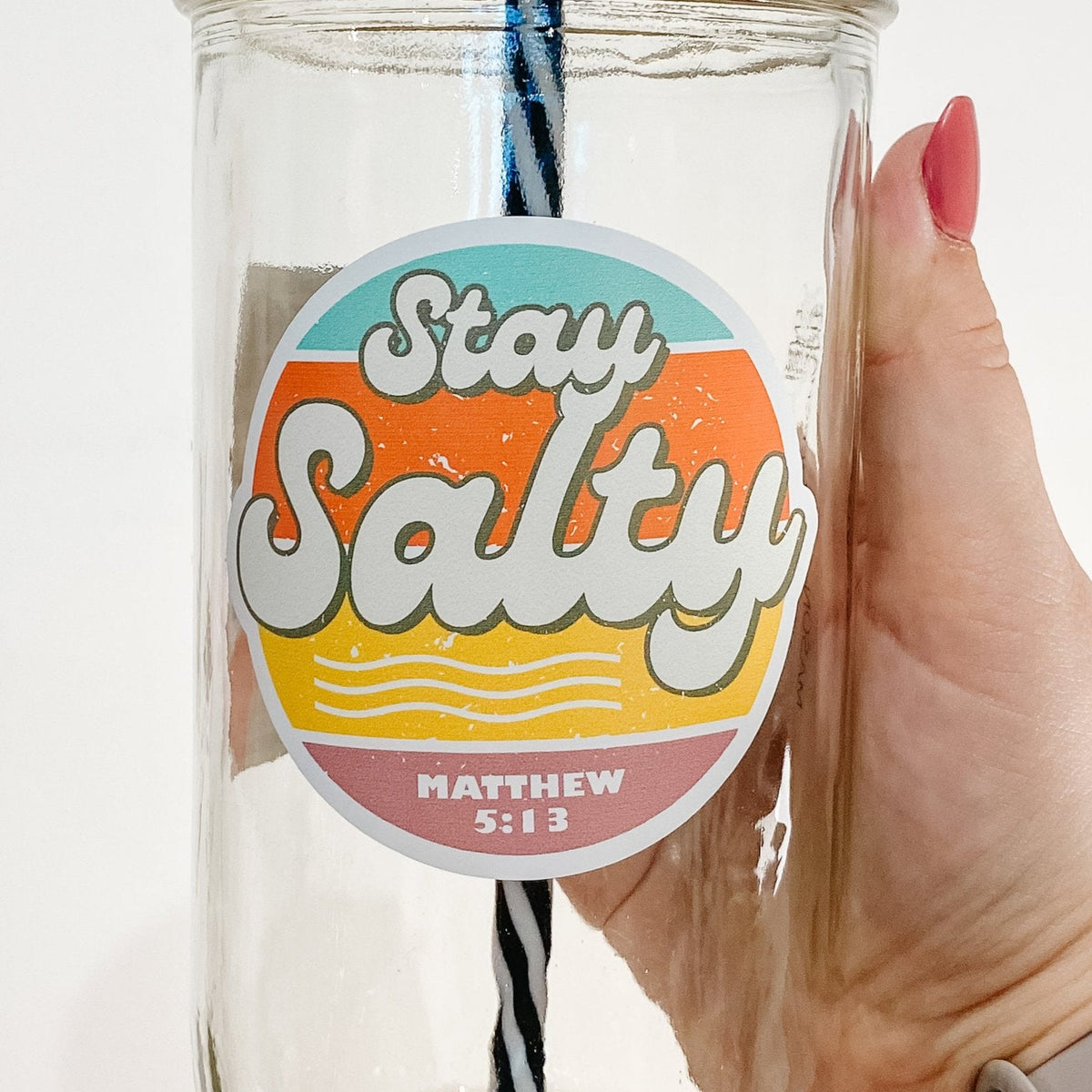 Close up of a hand holding a mason jar tumbler that says "stay salty" in big letters and "Matthew 5:13" lower in smaller text.