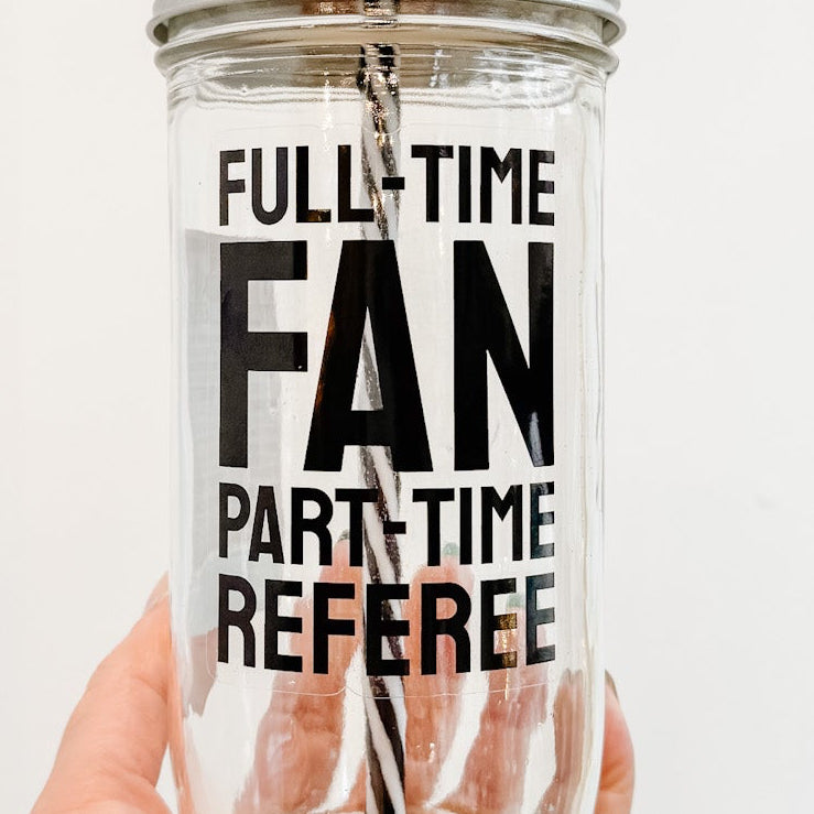 Tumbler with 'Full-Time Fan, Part-Time Referee' text held by a hand against a white background