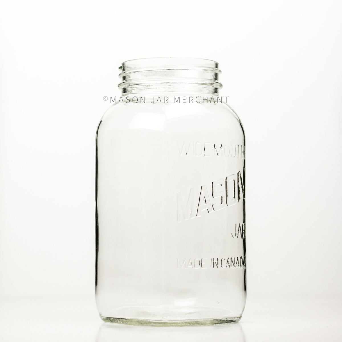 A side view of a Wide mouth half-gallon mason jar with Mason logo, against a white background