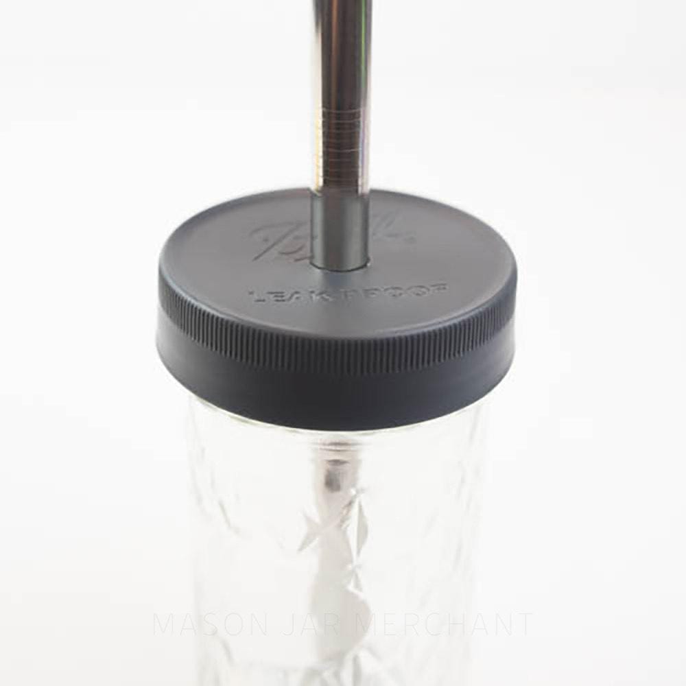 close up of an all black plastic mason jar Ball straw lid on a glass mason jar with a black metal straw in it