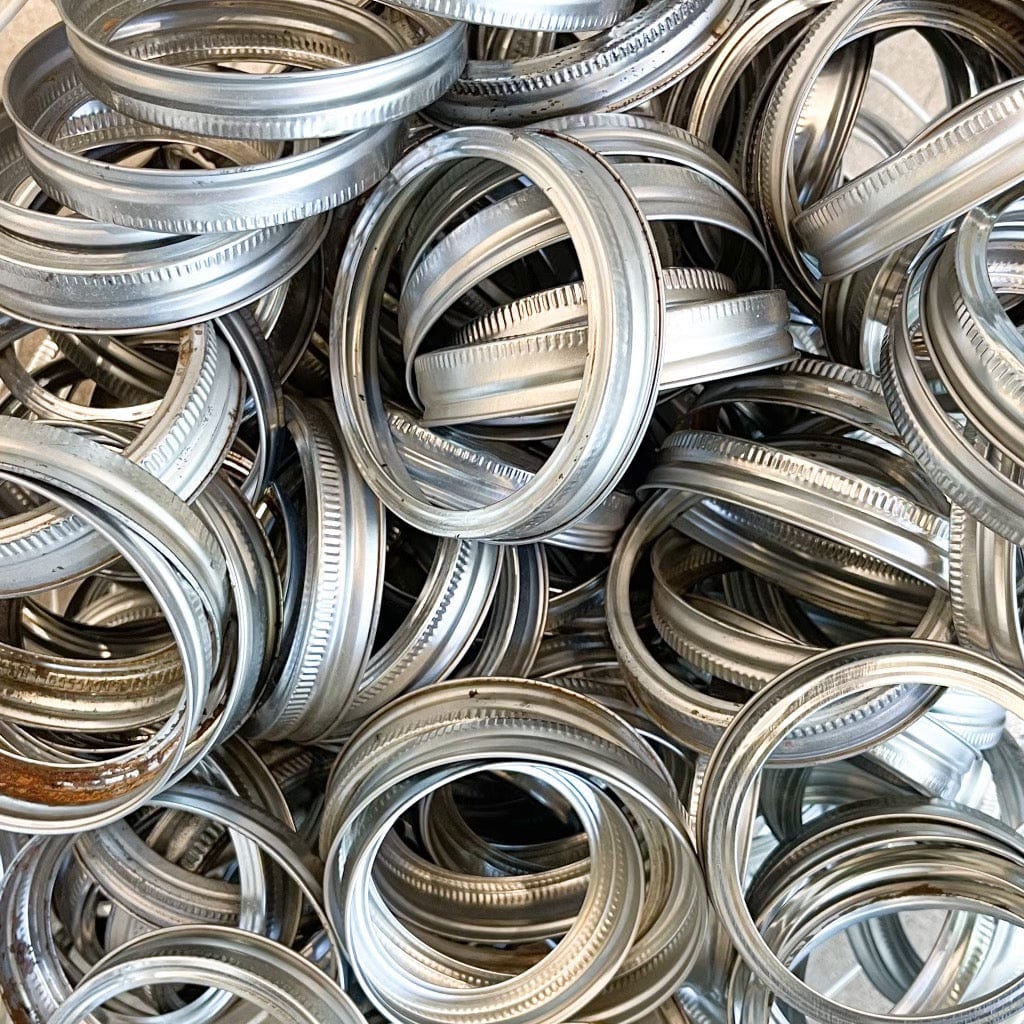image of silver, wide mouth rings for mason jars. There are rust spots and small blemishes on the rings