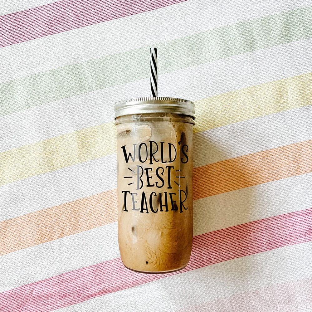 Tumbler with iced coffee with print that says "World' Best Teacher." Photographed against a striped picnic cloth.