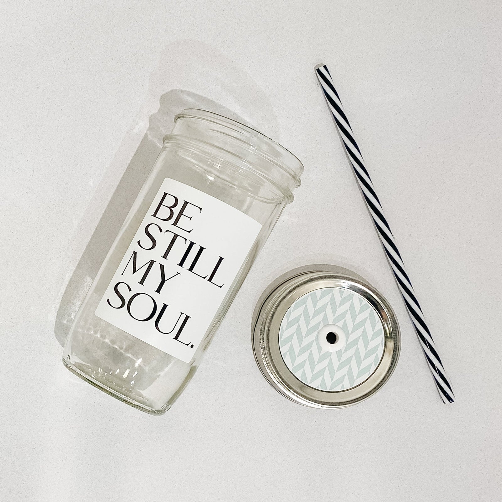 Hand holding a mason jar tumbler that says "be still my soul”