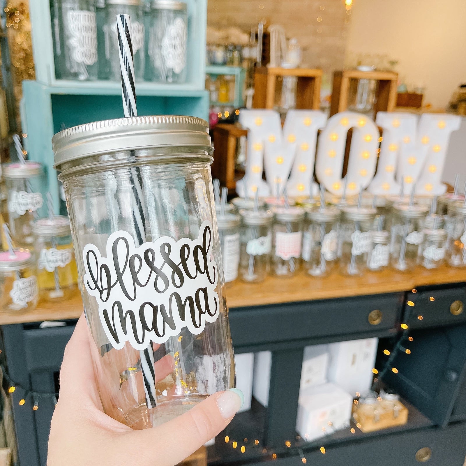 Hand holding a mason jar tumbler that says "blessed mama”