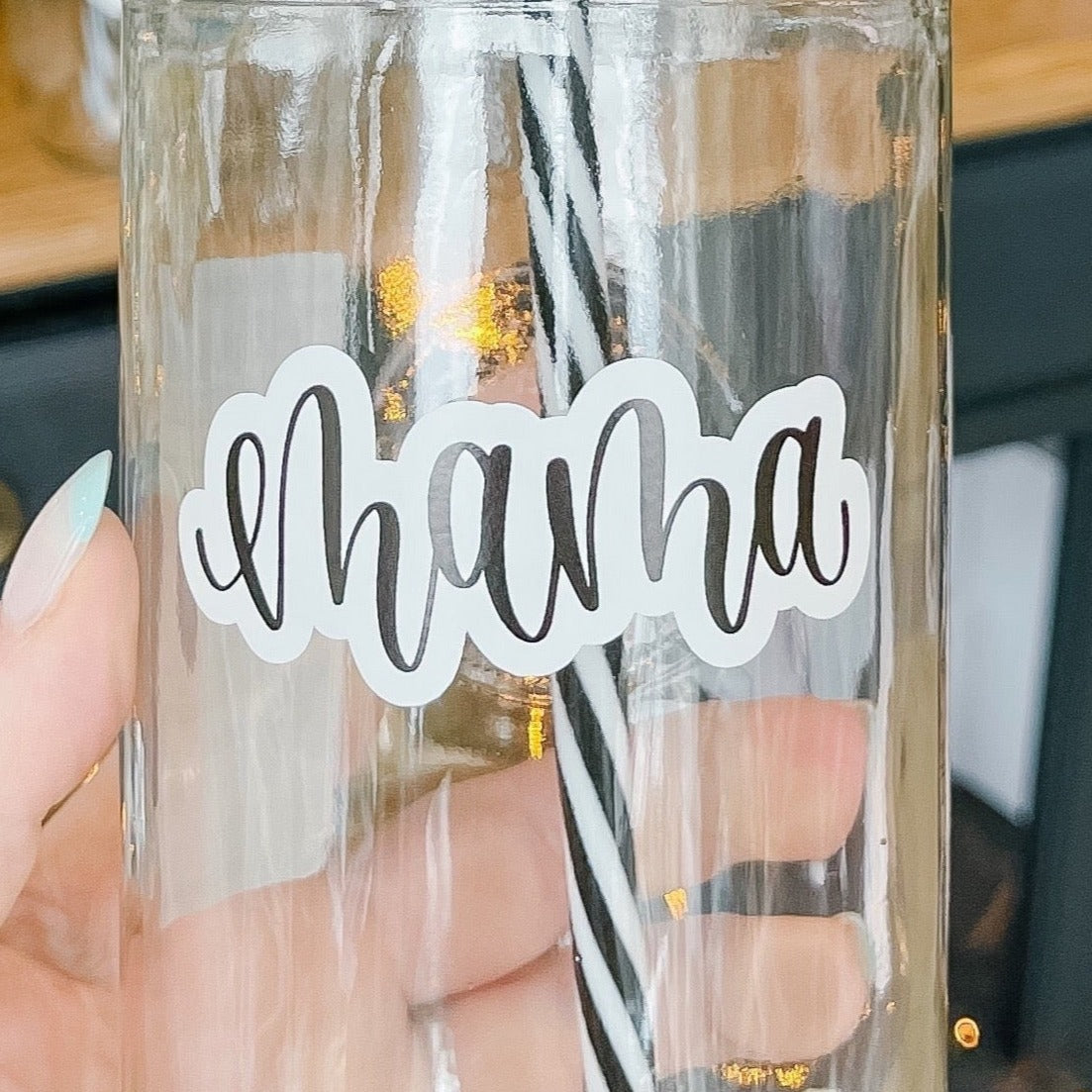 Hand holding a mason jar tumbler that says “mama” in black script on a white background