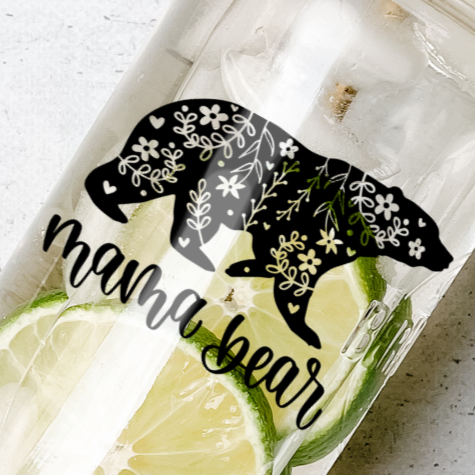 Close up of a mason jar tumbler that has a bear with a floral design and the words “mama bear”