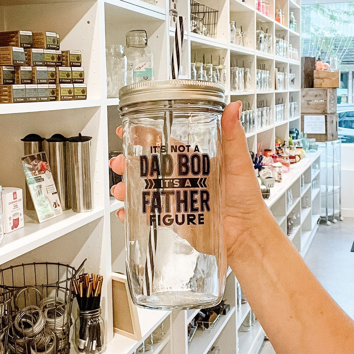Close up of a mason jar tumbler that says “it’s not a dad bod, it’s a father figure”