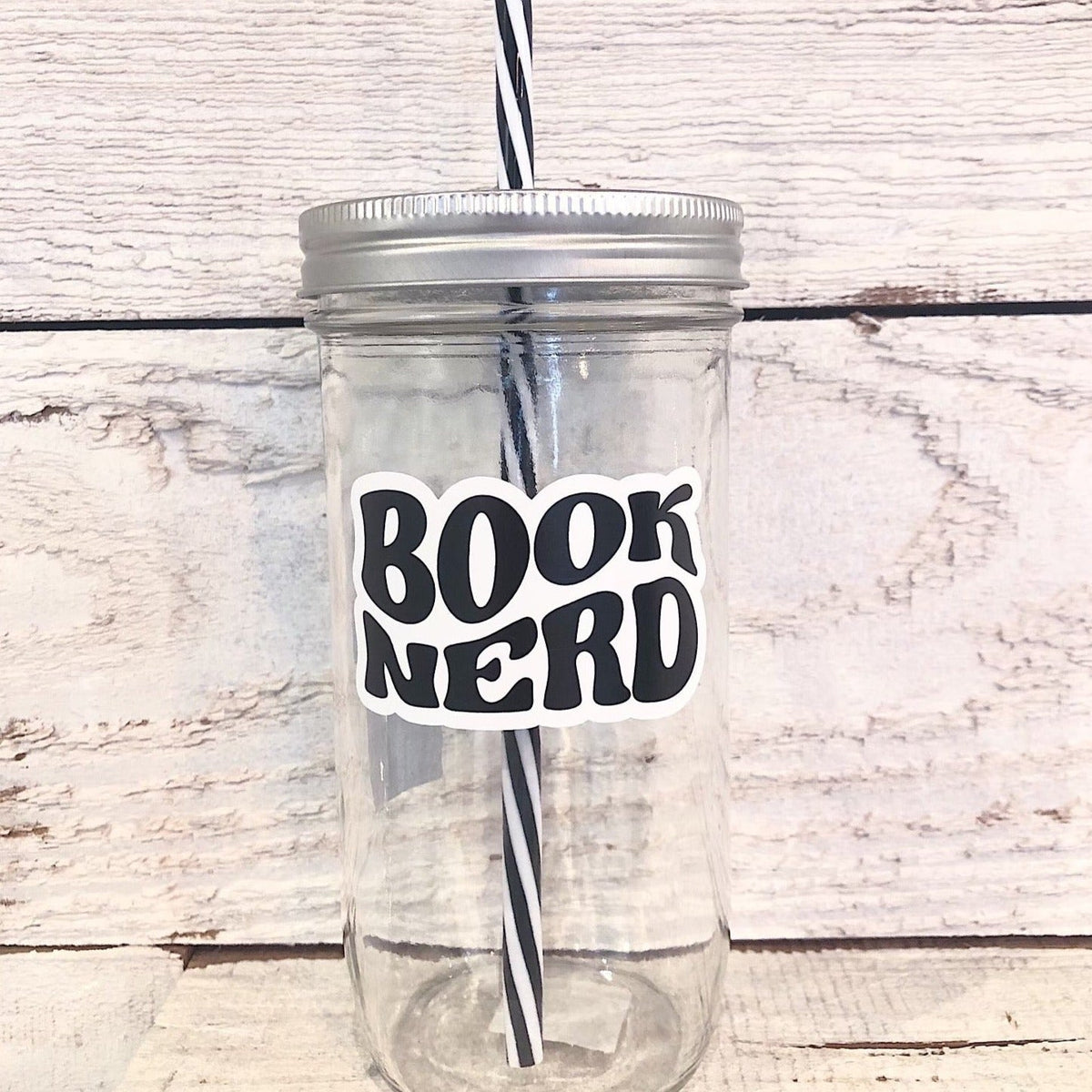 Mason jar tumbler that says "book nerd” in black bubble letters.