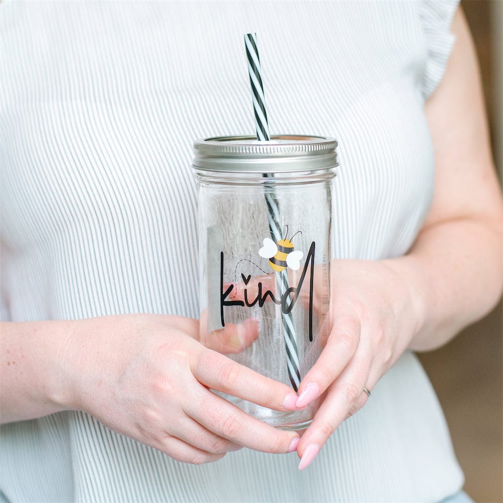 Photo of a mason jar tumbler with print of a bee and a word that says "kind".