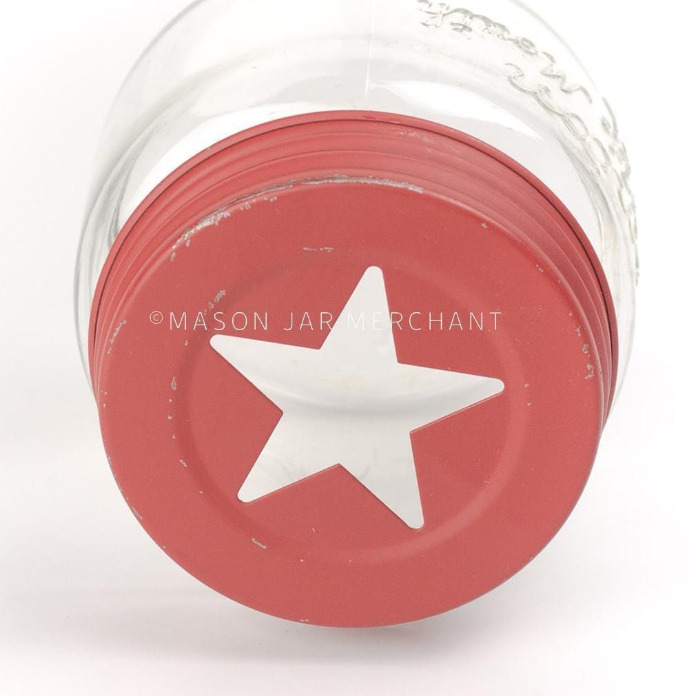 close up of a rustic red star cut out lid on a glass mason jar on a white background