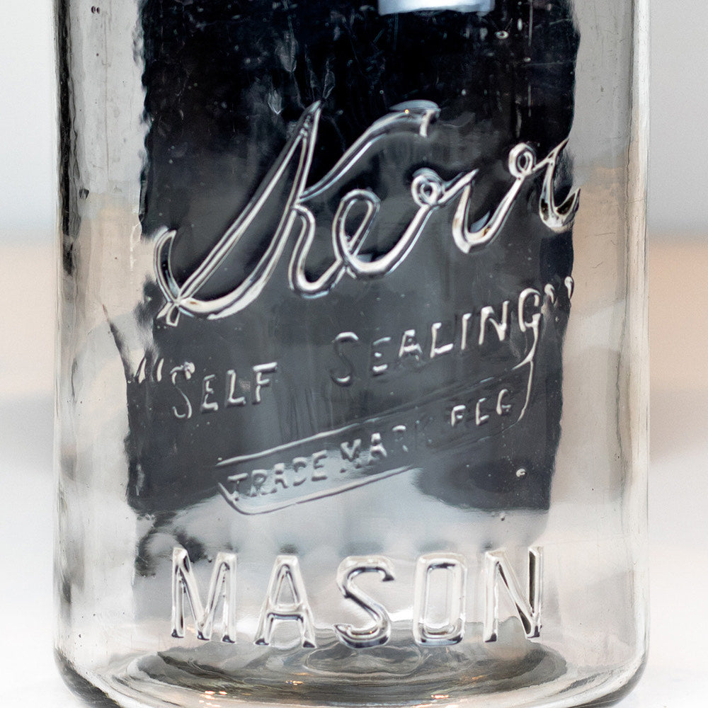 Close-up of the Kerr &quot;self-sealing&quot; Mason logo on a vintage quart mason jar