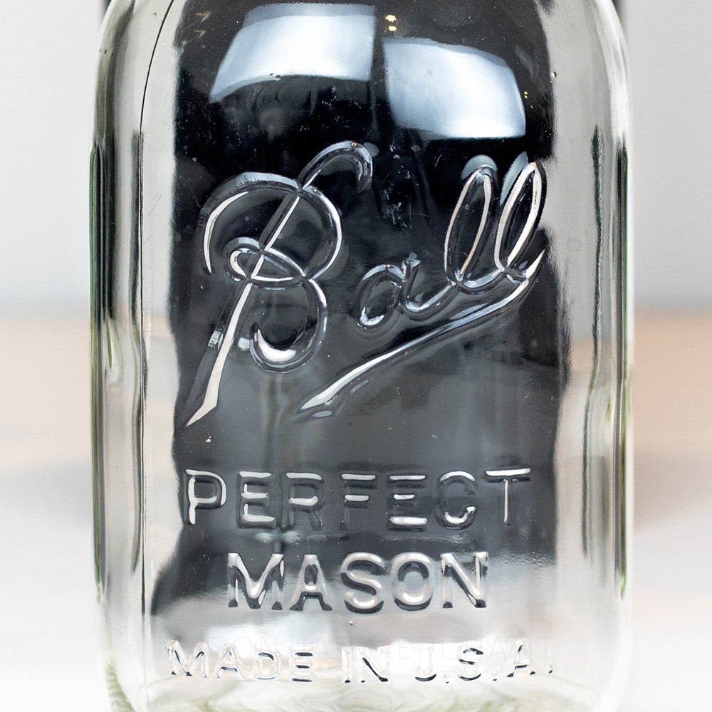 close up of a Ball regular mouth quart mason jar with logo showing on a white background