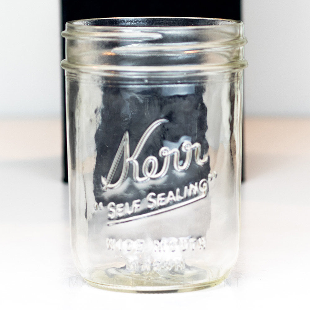 A close up of a Kerr &quot;self sealing&quot; glass mason jar on a white background